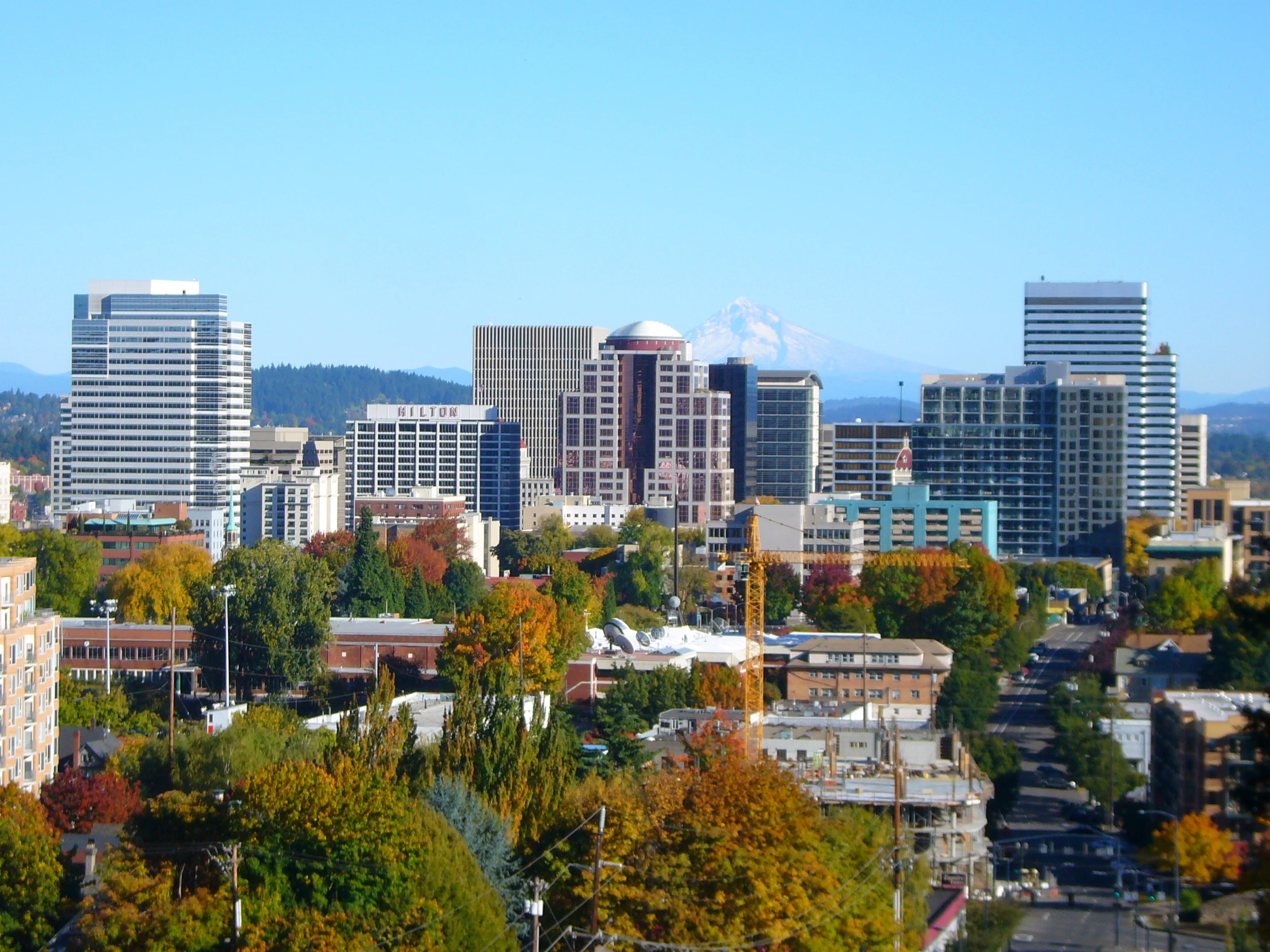 a city has tall buildings with mountains in the background