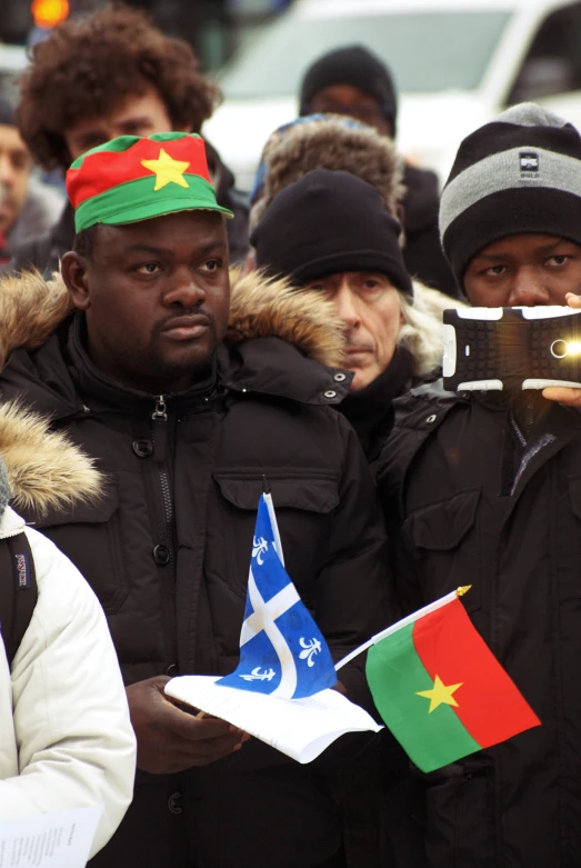 a man taking pictures in front of people dressed in winter gear