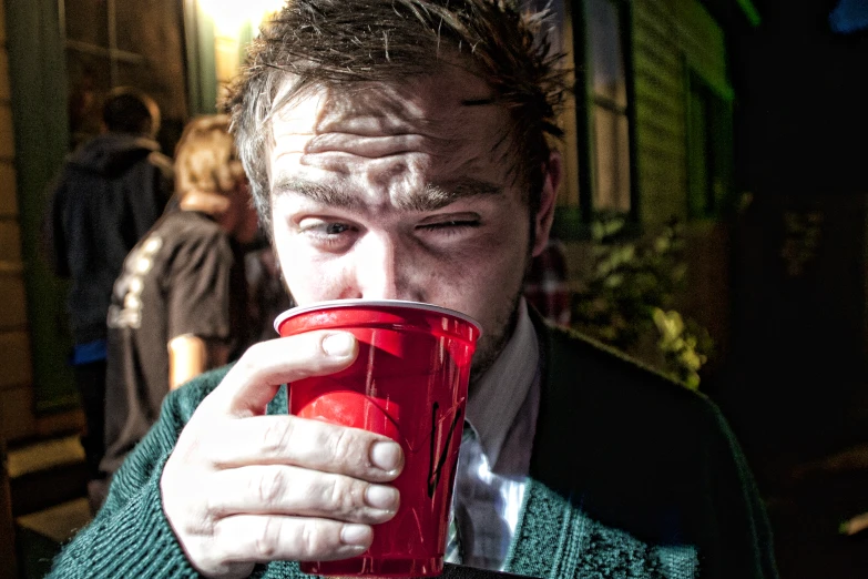 a man holding a red cup of coffee