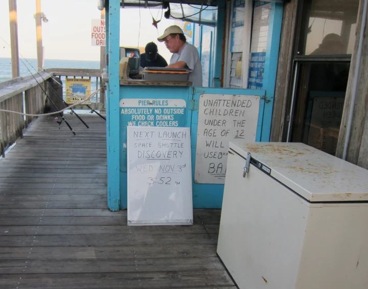 a man sitting at the end of a pier