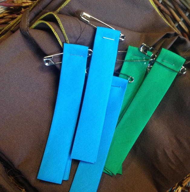 four different colored paper binders on the side of a bag