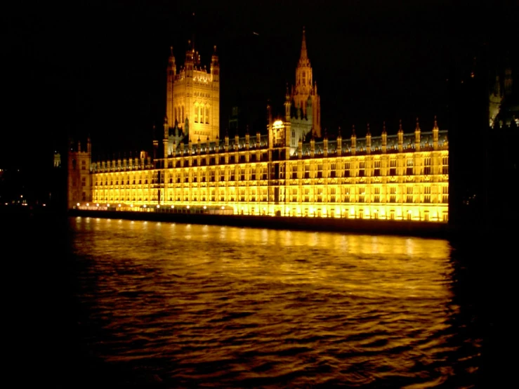 a castle at night lit up by the light of water