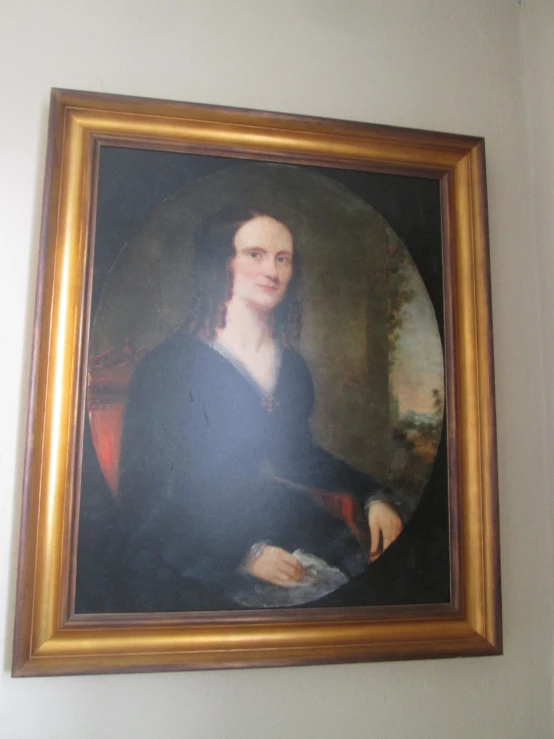 the framed portrait of a woman is mounted on a wall