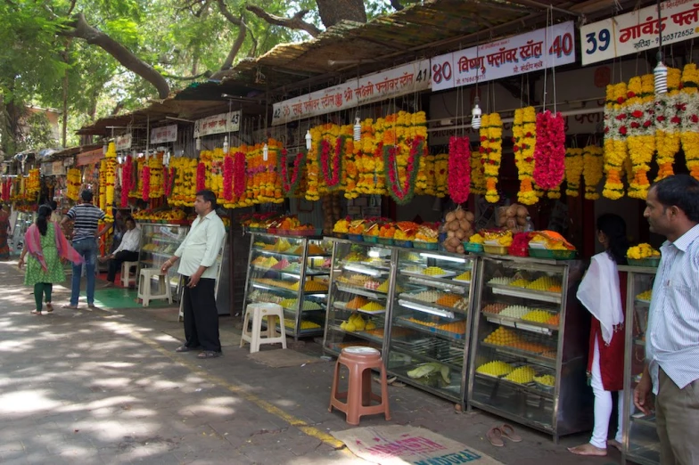 people are looking for flowers on display at a market