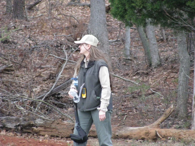 woman walking down a trail talking on her cell phone