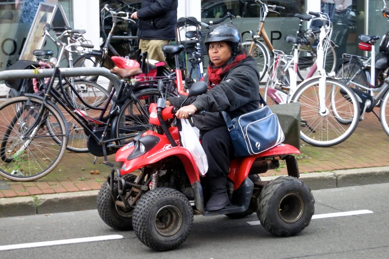 a woman in a helmet and jacket sitting on an four wheeler