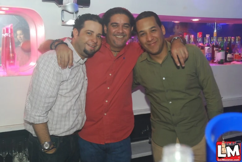 three men posing for the camera at an event