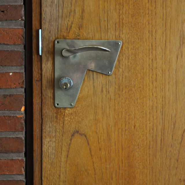 a door lock on a wooden door with brick background