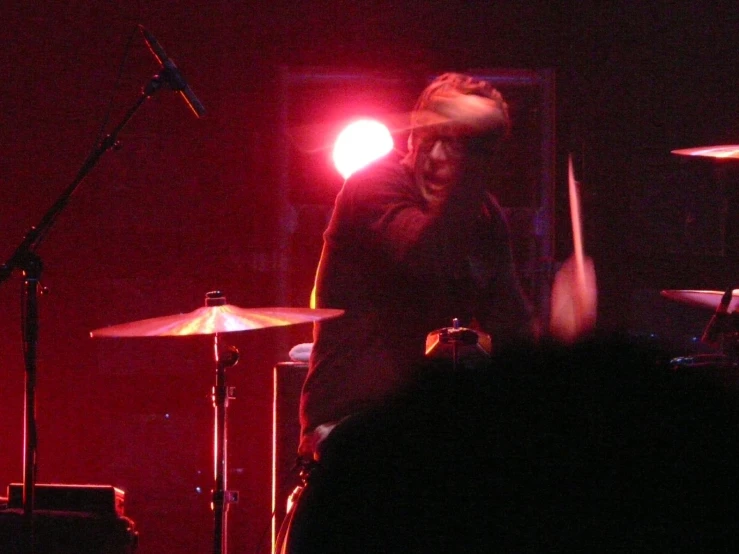 some men playing drums in front of some microphones