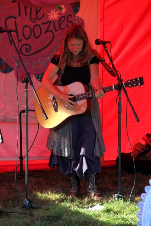 a person is playing an acoustic guitar at a festival