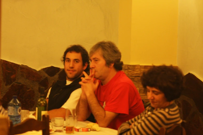 three men and one woman sitting at a table