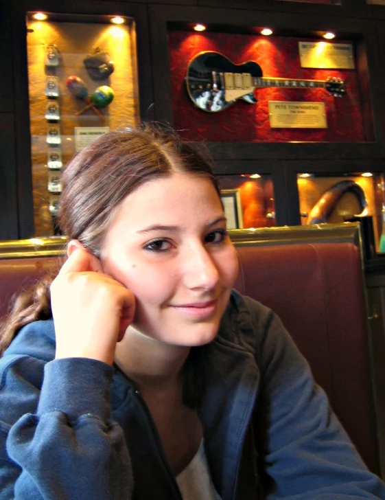 a young woman smiling next to a restaurant booth