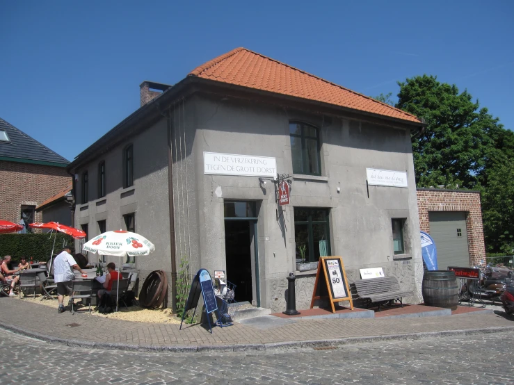 a couple people sitting outside of a small house