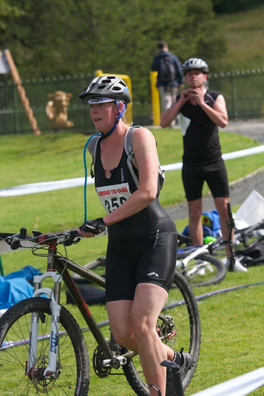 a woman is running on her bike while other people watch