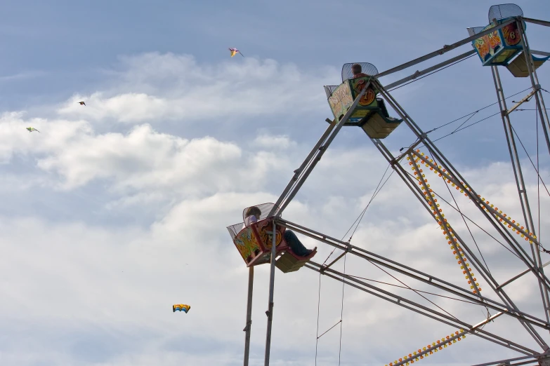 several people ride the amut wheel against the cloudy blue sky