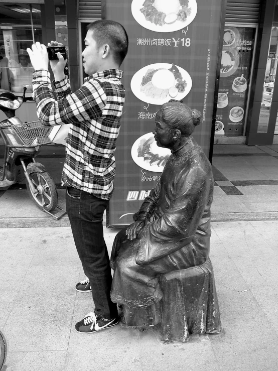 a little boy standing next to a large statue