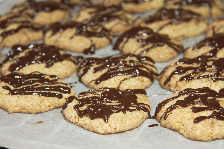 cookies with chocolate drizzle on a cookie sheet