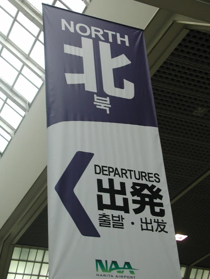 a large sign hanging from the ceiling in an airport