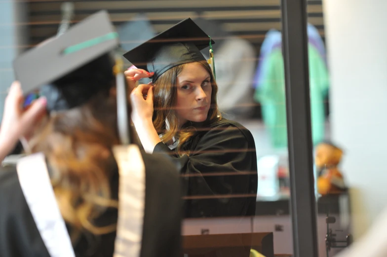 a woman in a cap is getting her graduate's gown