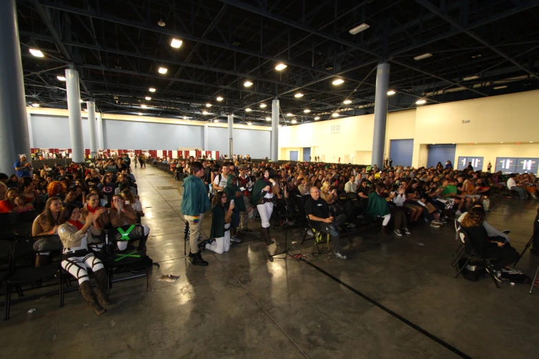 several people are sitting in chairs and watching others