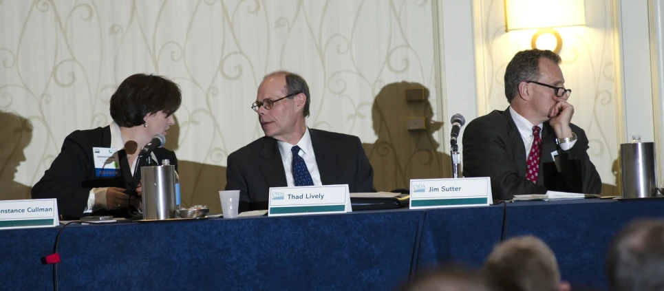 four people in suits sit at a table