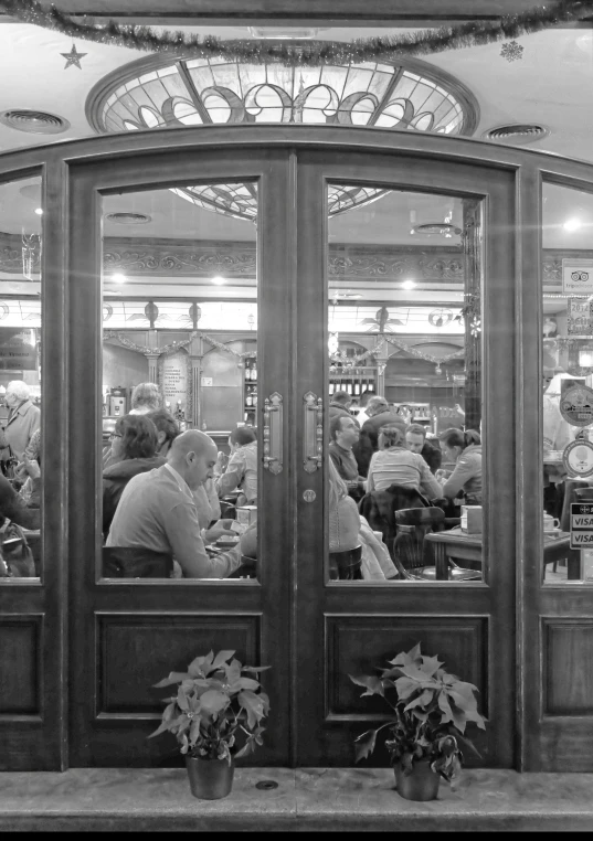 a man sitting inside of a restaurant next to two women