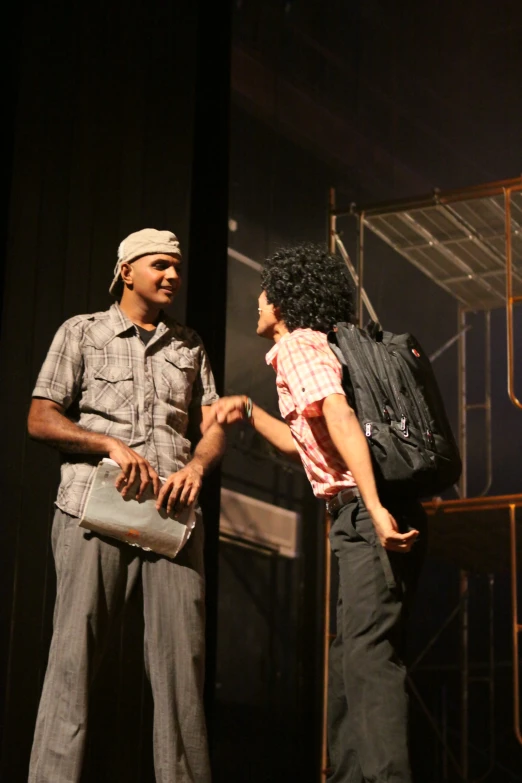 a man and a woman on stage with handbags