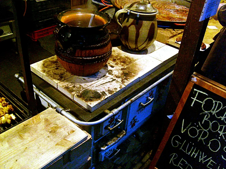 various jars, pots and knives sit on top of an old stove