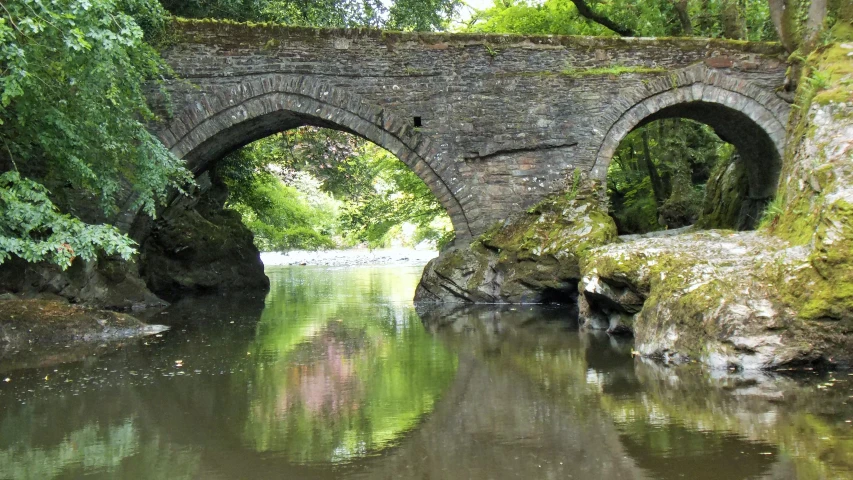 an old bridge crossing a small stream in the woods