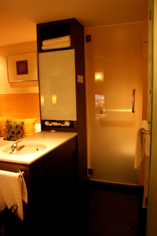 an all white bathroom with yellow and brown lighting