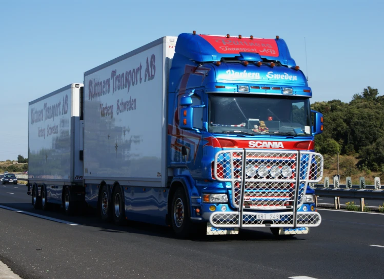 a big blue truck traveling down the road