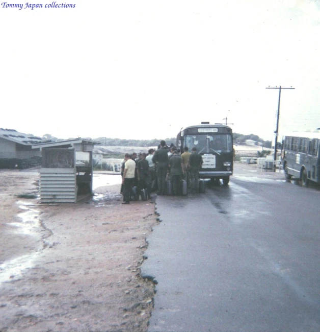 a group of people standing around a bus