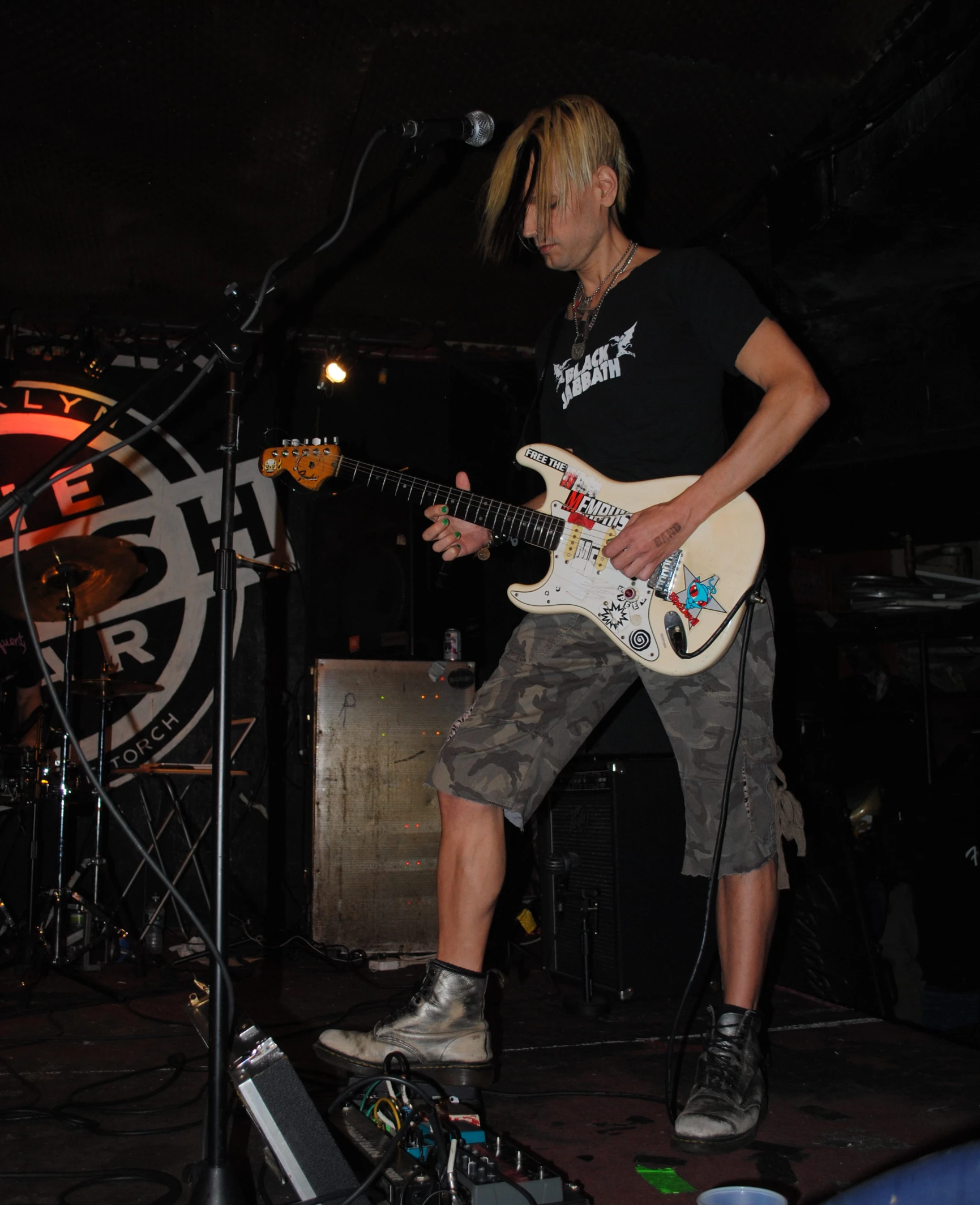 a man that is standing on a stage with a guitar