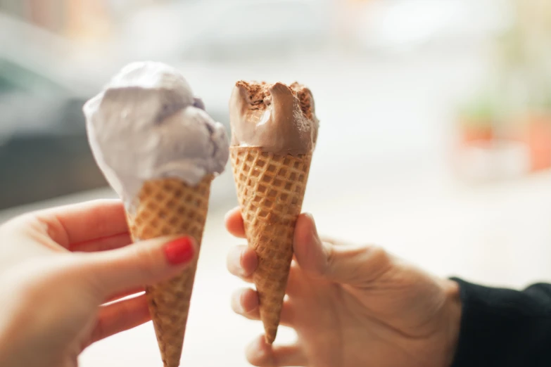 two people eating ice cream in their hands