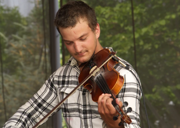 the man is playing on his violin outside