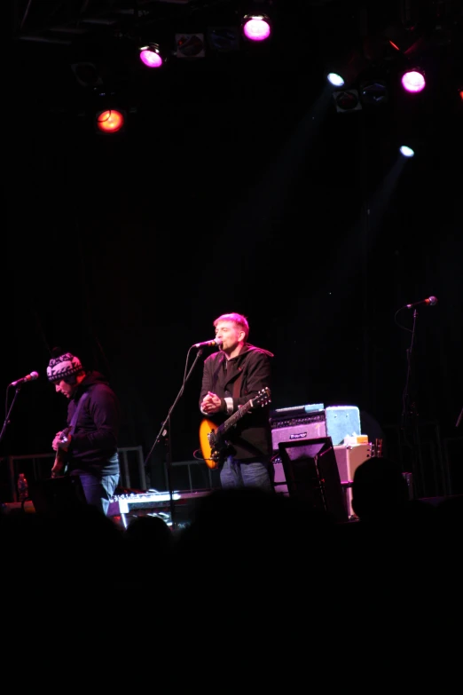 a man with a guitar playing on stage