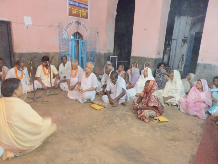 several people are sitting on the ground playing instruments