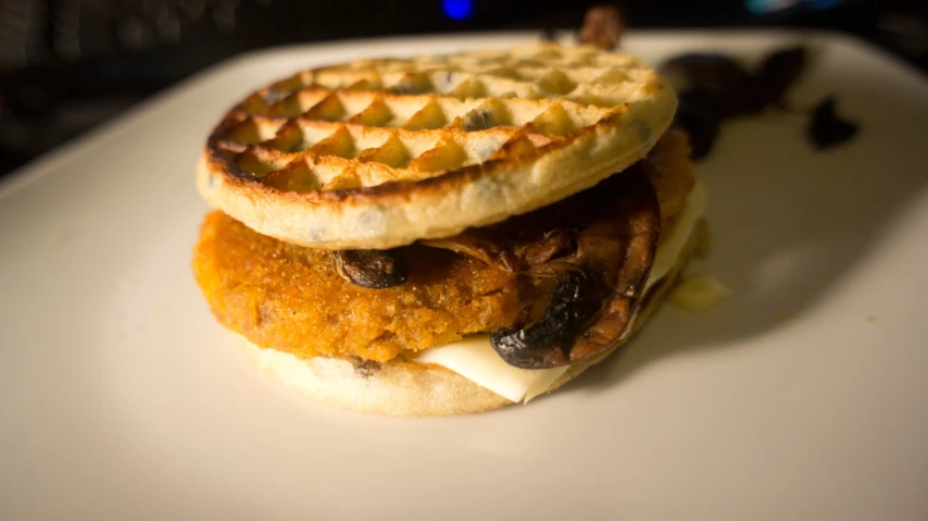 two waffles with chicken, lettuce and cheese are stacked on top of each other