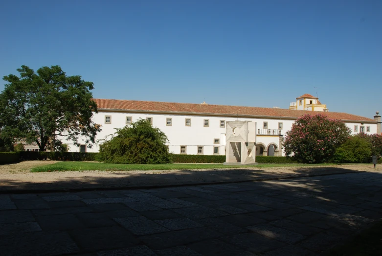 white building with red roof next to trees