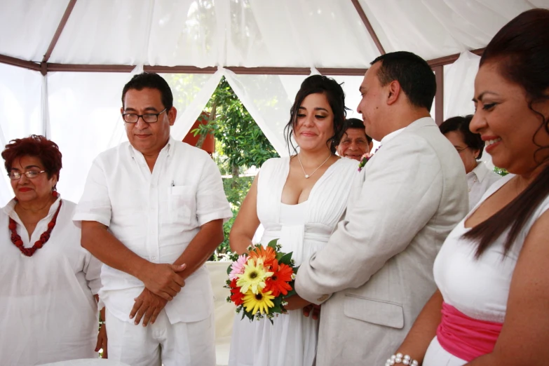 a couple getting married while the man is placing flowers