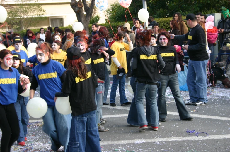 a large group of people with their faces painted as they walk together