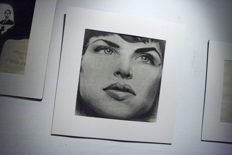 a woman's face and other drawings on a white wall