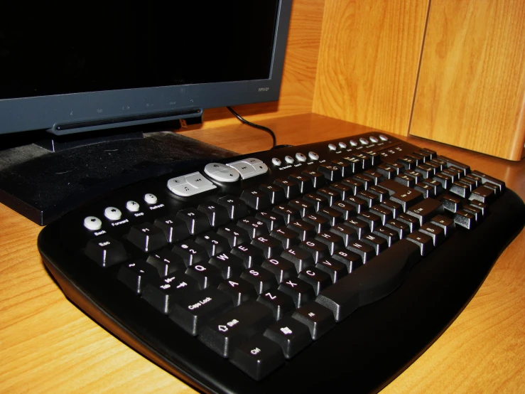 the computer keyboard is near the television monitor