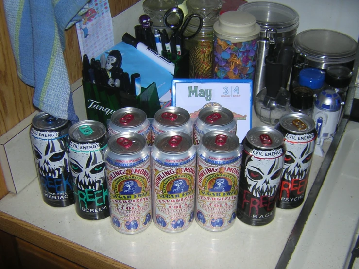 several cans of beer next to a note on a counter