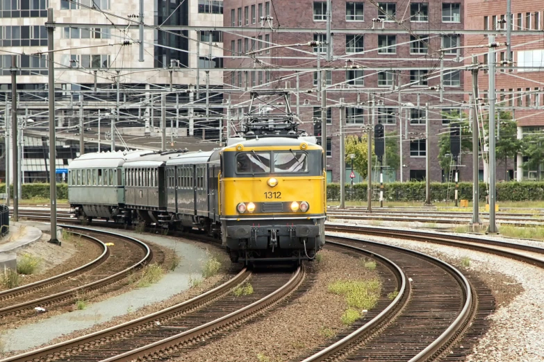 a passenger train coming down the track through a city