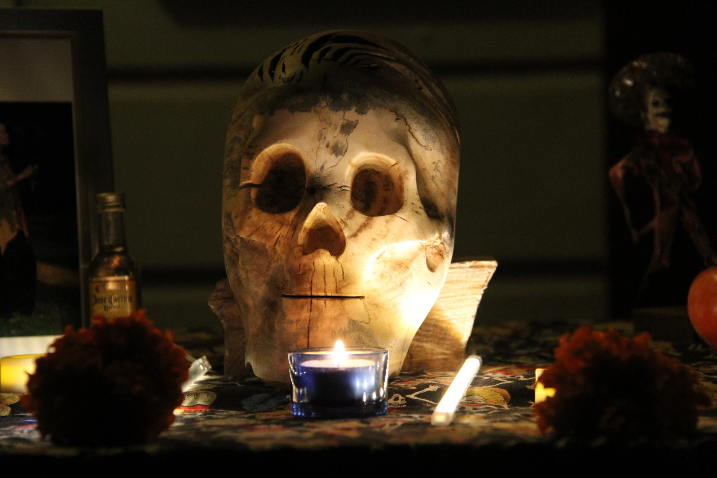 an illuminated candle near a creepy figure with a mirror