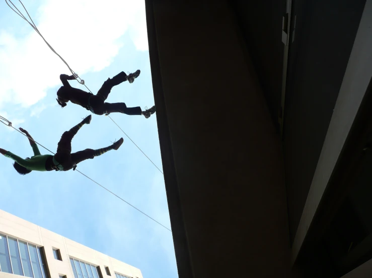 a group of people hanging from the side of a building