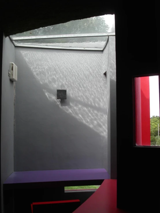 a corner of a house with a toilet and window