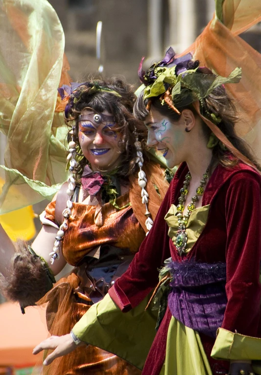 three young women dressed in costumes, one is smiling