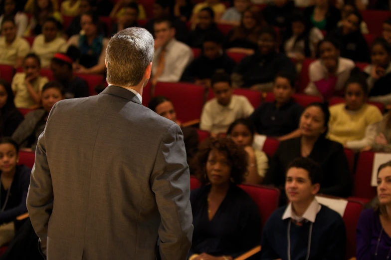 a man with his arm folded in front of an audience